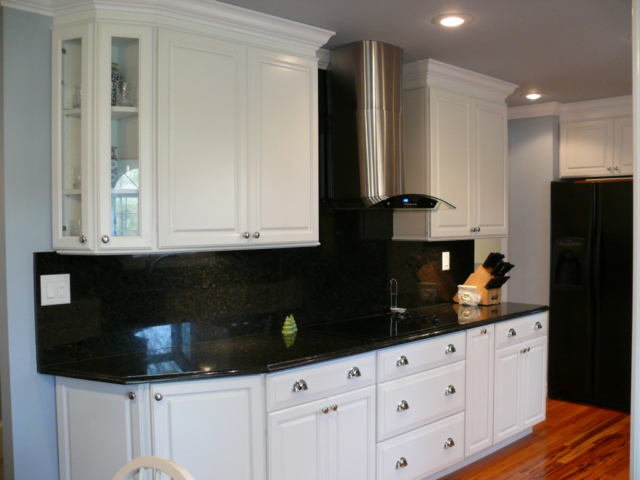 Remodeled galley kitchen with glass door corner cabinet by Kemper Cabinets a Masterbrand Company